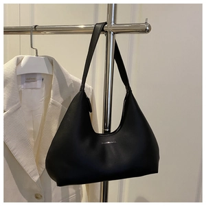 Close-up of black matte leather hobo bag with silver logo on a minimalist background