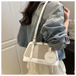 Close-up of canvas patchwork tote with adjustable strap and Fashion Bag pendant