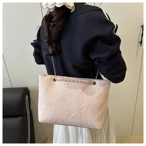 Détail du sac cabas rose avec broderie en losange et bandoulière chaîne dorée