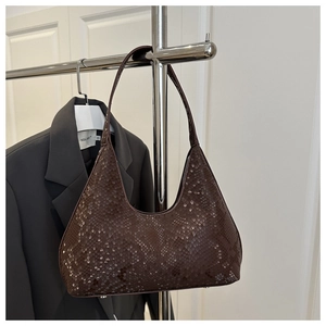 Detailed close-up of dark brown snakeskin embossed hobo bag with silver bottom studs