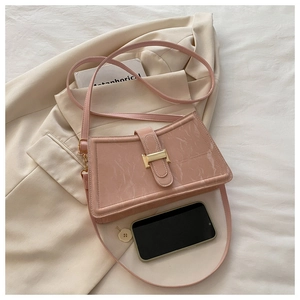 Detail of pink marble pattern PU leather with golden H-shaped hardware buckle close-up