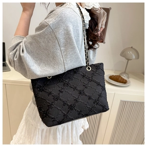 Détail du sac bandoulière noir à chaîne avec texture matelassée et paillettes