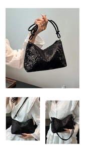 Close-up of black faux snake pattern shoulder bag with elegant knot detail on strap
