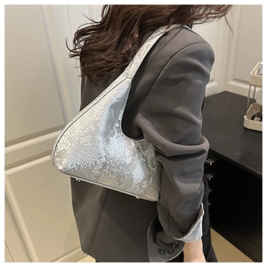 Macro shot of silver snakeskin texture on a semi-moon hobo bag with metallic finish