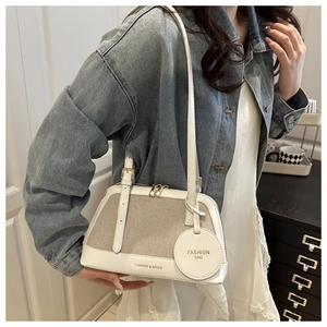 Detail of linen stitching and white leather strap on a chic Boston bowling handbag