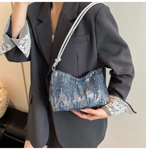 Detailed view of deep blue sequined shoulder bag with silver rope strap and knots