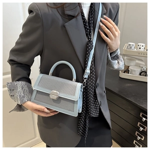 Détail du sac bandoulière bleu clair avec texture tressée et fermoir en argent