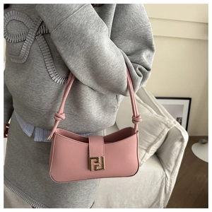 Detail of pink faux leather handbag with knot strap and gold geometric metal buckle