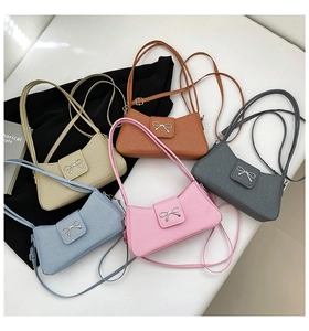 Detail showing various colors of vintage bow shoulder bags with silver metal hardware