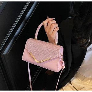 Detail of pink rhinestone handbag with golden V-clasp and shimmering crystal surface