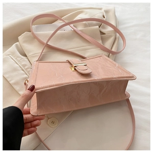 Detail view of pink baguette bag with marble textured leather and golden metal clasp