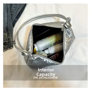 Internal capacity of silver snakeskin textured shoulder bag with cosmetics inside