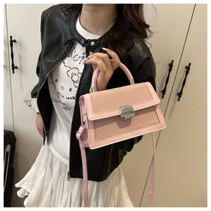 Détail du sac bandoulière rose tissé avec boucle en métal argenté et bandoulière réglable