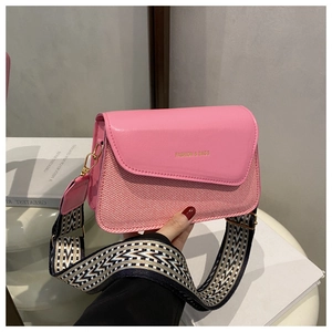 Detail of pink PU crossbody bag with wide geometric pattern strap and gold hardware