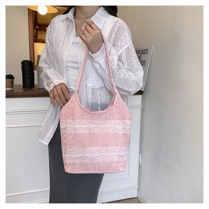 Gros plan d'un sac cabas en dentelle rose avec broderies florales et bandoulière