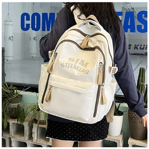 Detail of white nylon backpack with SIM SIJIMIAO embroidery and khaki strap buckles