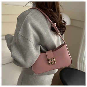 Detailed shot of pink crossbody bag with golden geometric clasp and knotted strap detail