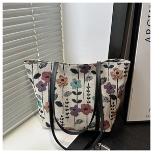 Close-up of colorful floral jacquard fabric and slim black straps on a tote bag