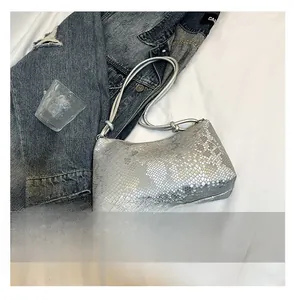 Detailed macro view of silver snake-embossed faux leather texture on minimalist shoulder bag