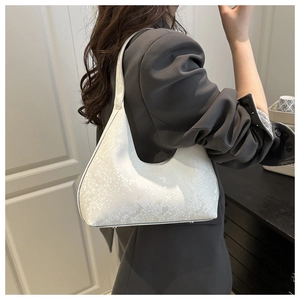 Detailed texture of white snake skin pattern on a trendy half-moon hobo shoulder bag