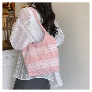 Gros plan d'un sac à bandoulière en dentelle rose avec des bordures crochetées blanches