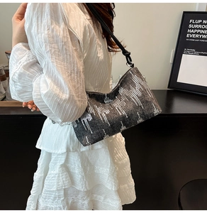Chic silver sequin baguette bag worn over the shoulder with white lace dress