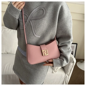 Detailed view of pink leather shoulder bag featuring a gold FF metal buckle on a model