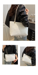 Trois vues d'un sac cabas blanc texturé avec bandoulière chaîne sur une veste noire