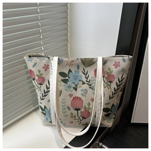 Close-up of colorful floral embroidery and textured fabric on large shoulder tote bag