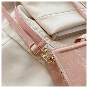 Close-up of pink baguette bag with marble texture, gold buckle, and adjustable strap