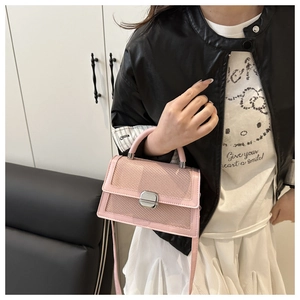 Détail du sac à bandoulière rose avec texture quadrillée, boucles et poignée argent