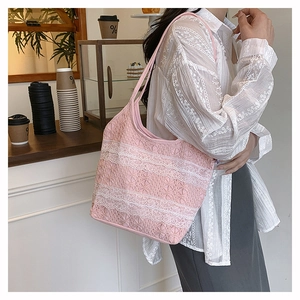 Détail du sac cabas rose clair avec rayures en dentelle blanche dans un café chaleureux