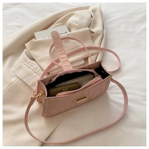 Detailed interior view of a pink baguette bag showing storage space and gold buckle