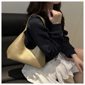Close-up detail of champagne gold glitter handbag with fashion and bags lettering