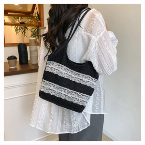Détail du sac cabas en dentelle crochetée avec motifs floraux noirs et bordure blanche