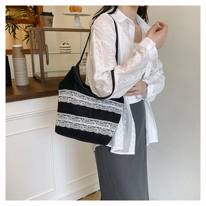 Détail du sac cabas noir avec trois rubans de dentelle blanche parallèles et bandoulière