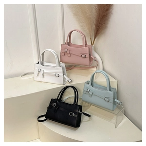 Detailed row of small bow shoulder bags in pink, white, black and blue pastel colors
