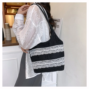 Détail du sac cabas en crochet noir avec bordure en dentelle blanche et fines bandoulières