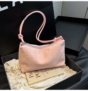 Detailed close-up of pink snakeskin pattern shoulder bag in luxury gift box