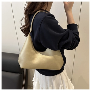 Detail of champagne gold hobo bag with metallic shimmer and fashion lettering