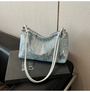 Detail of light blue denim underarm bag with silver sequins and double shoulder straps