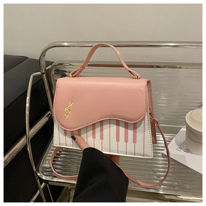 Detail of creative pink piano key pattern and gold musical note embroidery on handbag