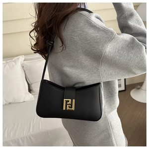 Detailed side view of black matte leather hobo bag with iconic gold geometric buckle