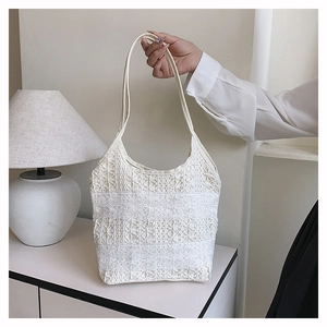 Détail du sac cabas en dentelle blanche avec textures florales et coutures superposées
