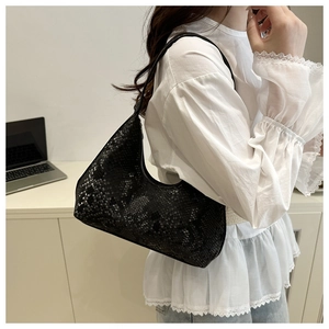 Detail of black snake-print hobo bag with textured finish and elegant zipper closure