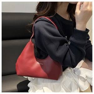 Close-up of deep red leather hobo bag worn by a model in a trendy casual style