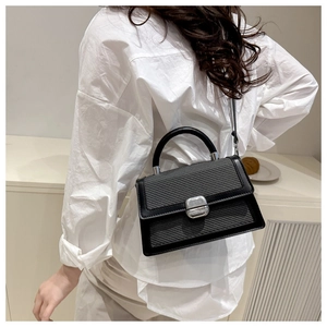 Vue détaillée de la texture tissée et boucle argentée sur sac à main noir et gris