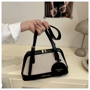 Detail of canvas and leather patchwork tote with dual zipper and fashion engraving