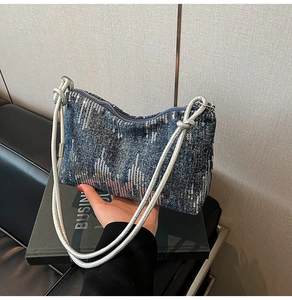 Detail of blue denim shoulder bag with silver sequins and metallic tube straps
