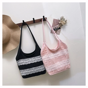 Détail de sacs cabas en dentelle rose et noir avec motifs floraux au crochet sur support